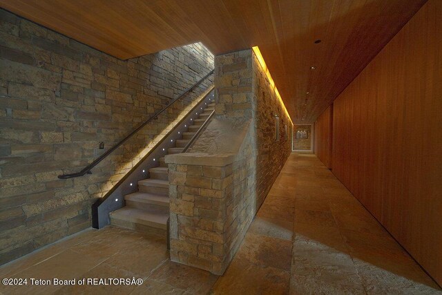 interior space featuring wooden ceiling and wooden walls