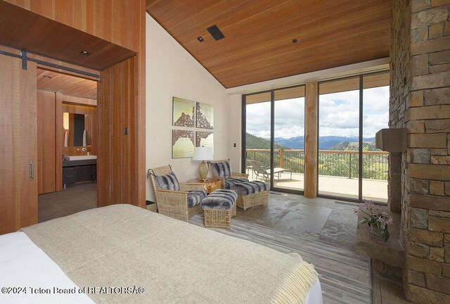 bedroom featuring lofted ceiling, access to exterior, a mountain view, wooden ceiling, and ensuite bath