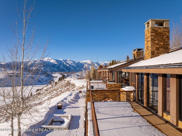 snow covered patio featuring a mountain view