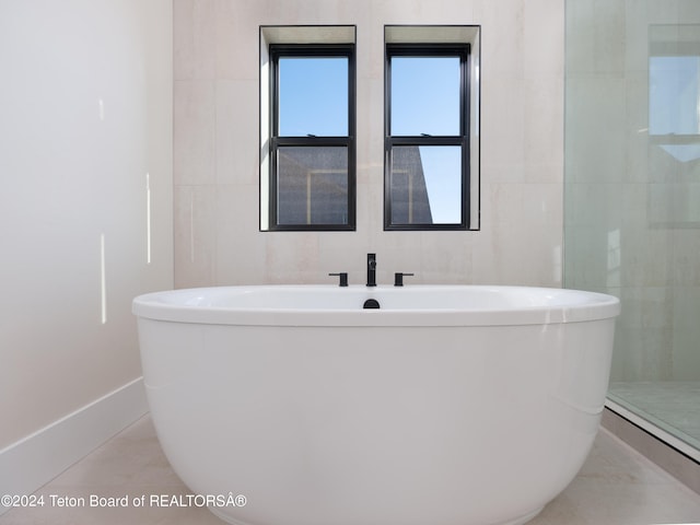 bathroom with a bath and tile patterned floors