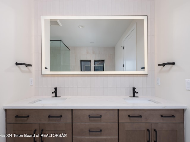 bathroom featuring vanity and backsplash