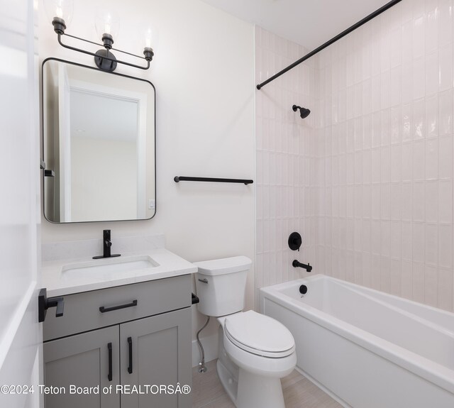 full bathroom featuring toilet, tiled shower / bath combo, and vanity