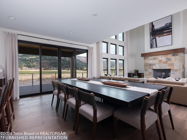 dining area featuring hardwood / wood-style flooring and a stone fireplace