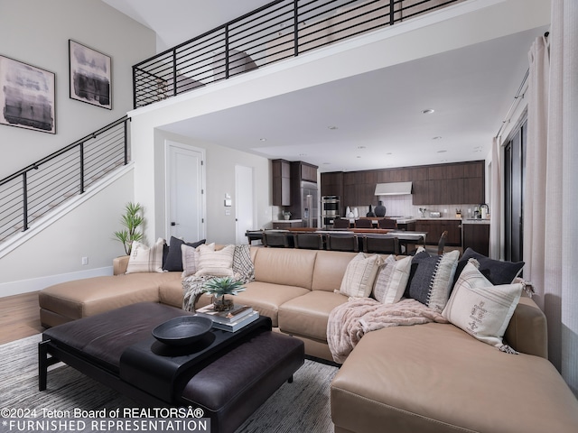 living room with wood-type flooring and a high ceiling