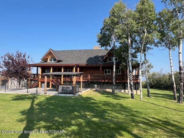 back of house featuring a wooden deck and a lawn