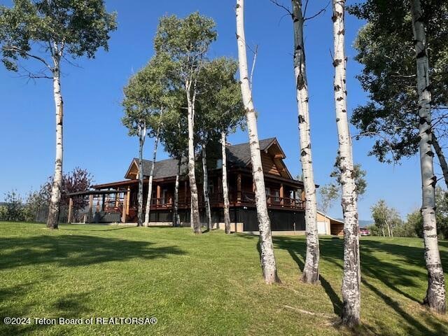 rear view of property with a lawn