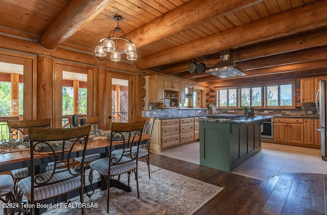 kitchen featuring a wealth of natural light, light wood-type flooring, beam ceiling, and a center island