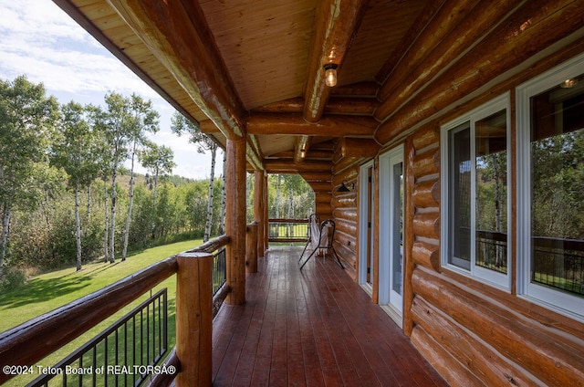 wooden terrace featuring a lawn