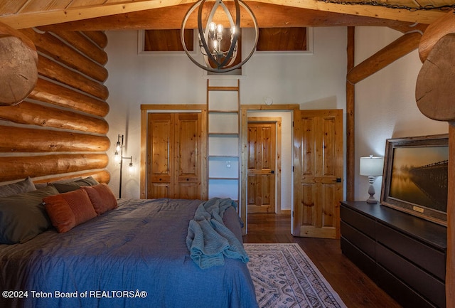 bedroom with beamed ceiling, rustic walls, a chandelier, and dark wood-type flooring