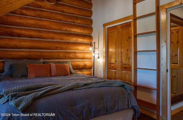 bedroom with log walls and a closet