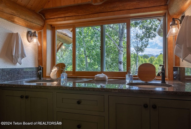 kitchen with dark stone countertops, wood ceiling, and sink