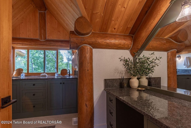 kitchen with wood ceiling, dark stone counters, gray cabinets, and vaulted ceiling with beams