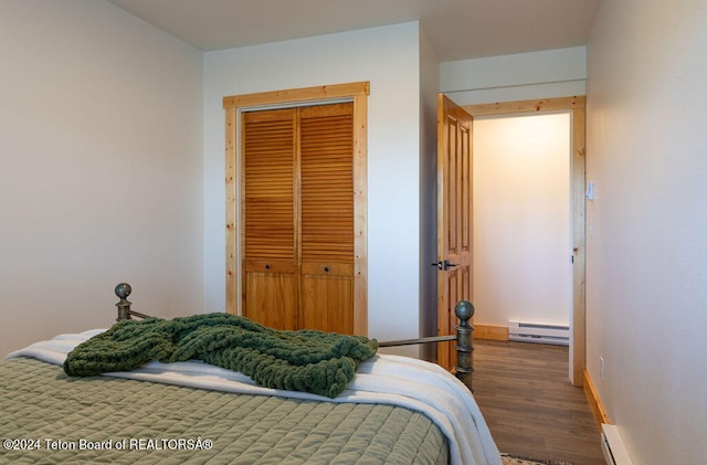 bedroom featuring a closet, dark hardwood / wood-style floors, and a baseboard radiator