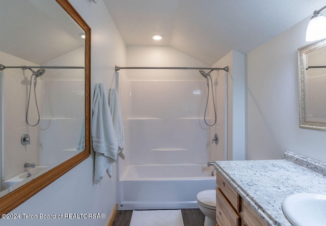 full bathroom featuring tub / shower combination, vanity, wood-type flooring, vaulted ceiling, and toilet