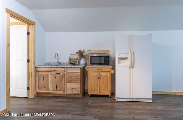 kitchen with light stone counters, sink, white refrigerator with ice dispenser, vaulted ceiling, and dark hardwood / wood-style flooring