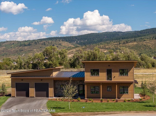 modern home featuring a garage, a mountain view, and a front yard