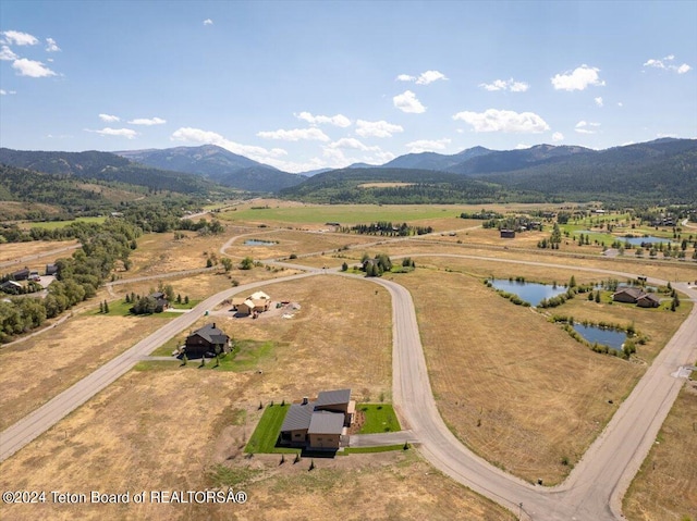 birds eye view of property featuring a rural view and a water and mountain view