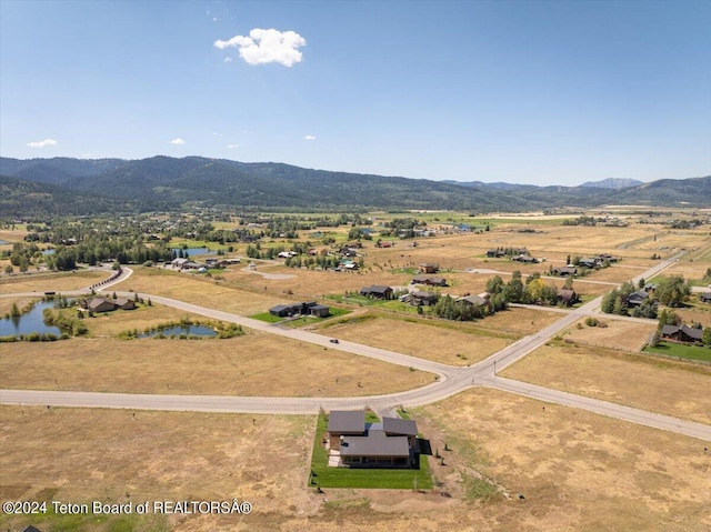 birds eye view of property featuring a water and mountain view and a rural view