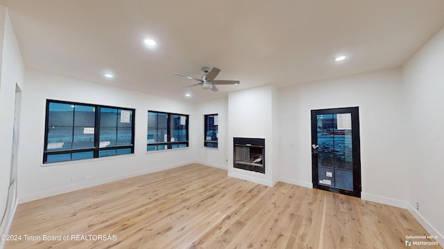 unfurnished living room with ceiling fan and light wood-type flooring