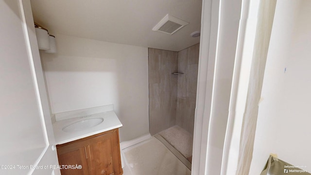 bathroom with vanity and tiled shower