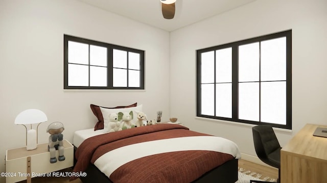 bedroom featuring hardwood / wood-style floors, ceiling fan, and multiple windows