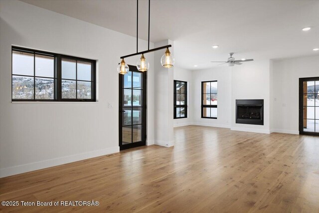 unfurnished living room with ceiling fan and light wood-type flooring