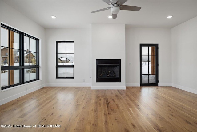 unfurnished living room with ceiling fan and light hardwood / wood-style floors