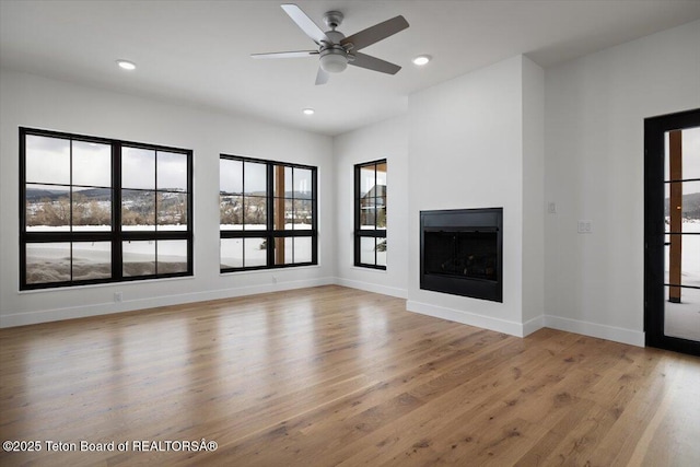 unfurnished living room featuring ceiling fan and light hardwood / wood-style flooring