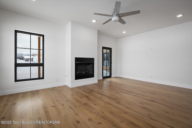 unfurnished living room featuring hardwood / wood-style flooring and ceiling fan