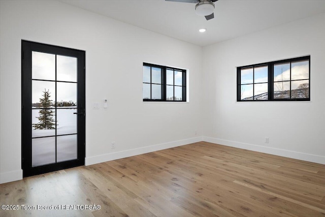 spare room with ceiling fan and light wood-type flooring