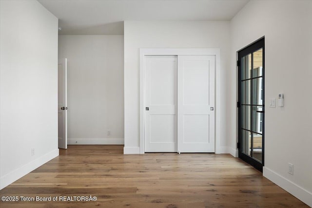 unfurnished bedroom with light wood-type flooring and a closet