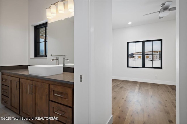 bathroom with vanity, plenty of natural light, hardwood / wood-style floors, and ceiling fan