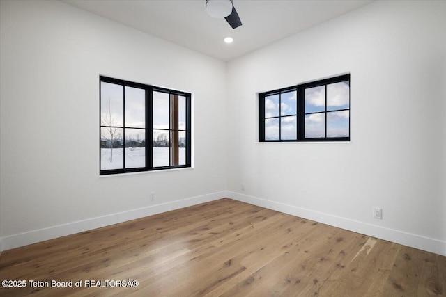 empty room with ceiling fan and light hardwood / wood-style floors