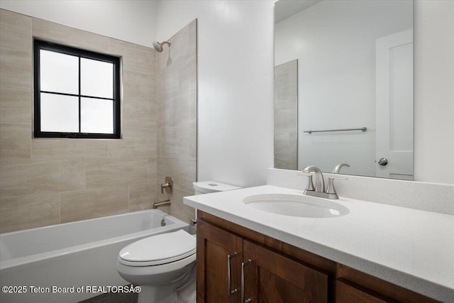 full bathroom featuring tiled shower / bath, vanity, and toilet