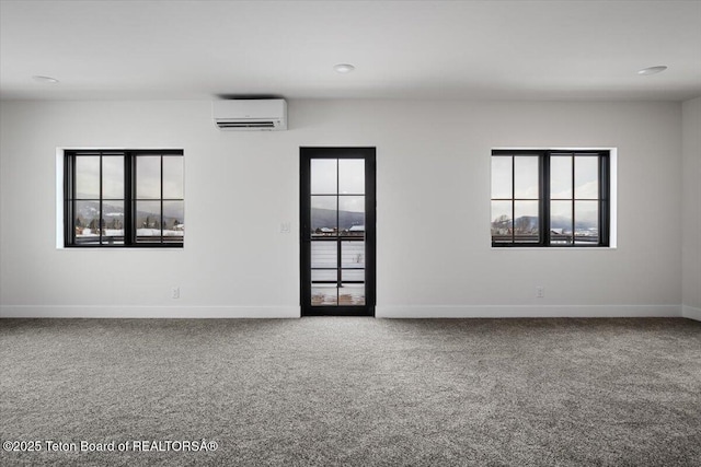 carpeted spare room featuring a healthy amount of sunlight and a wall unit AC