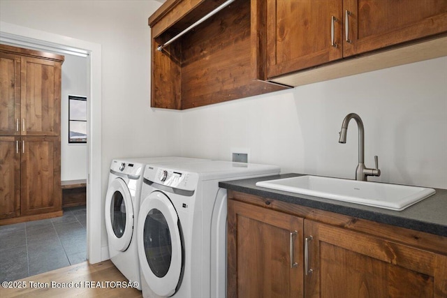 washroom featuring cabinets, sink, washing machine and clothes dryer, and dark tile patterned flooring