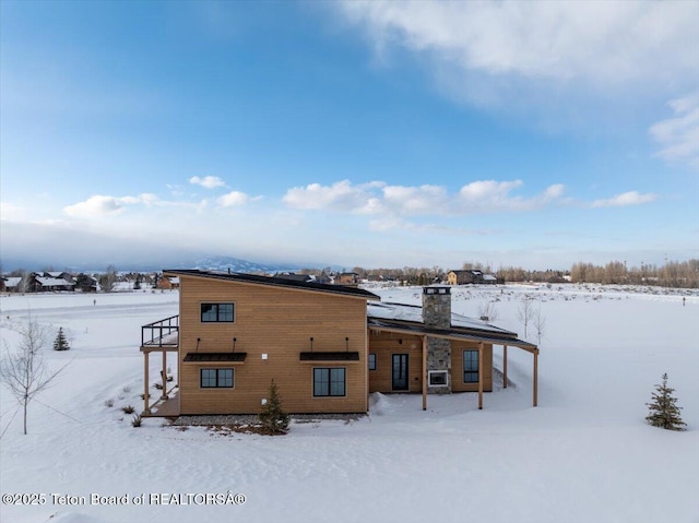 view of snow covered rear of property