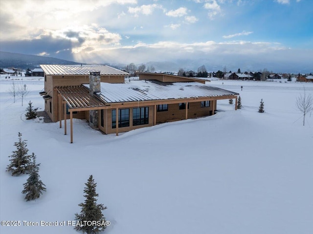 view of snow covered rear of property