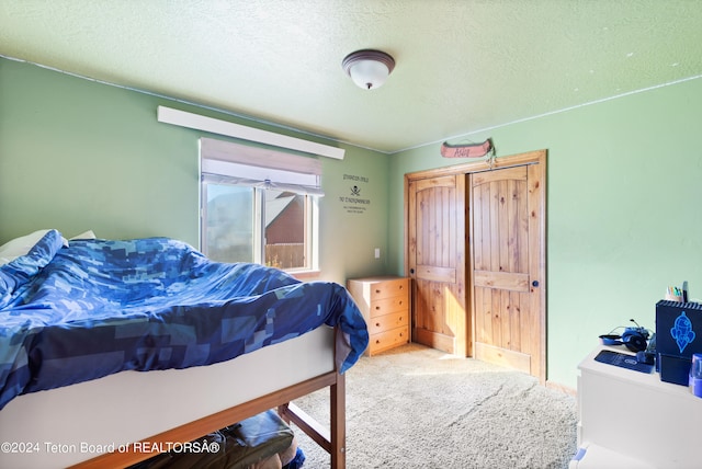 bedroom with a textured ceiling and carpet flooring