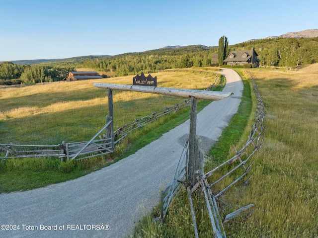 view of road featuring a mountain view, a rural view, and driveway