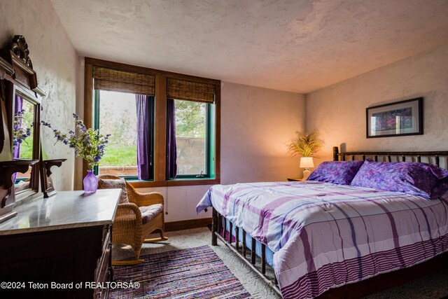 bedroom with light colored carpet and baseboards