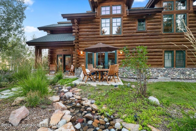 back of house featuring a patio and log siding