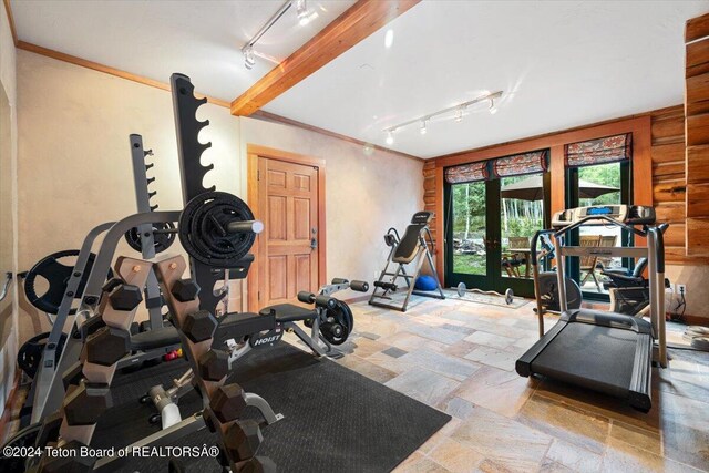 exercise room featuring stone tile flooring, french doors, rail lighting, and ornamental molding