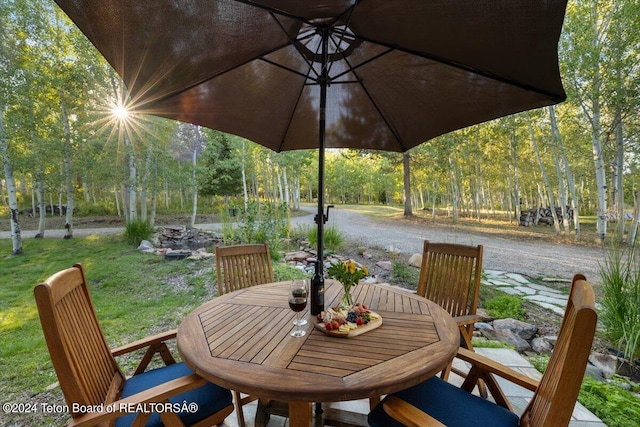 view of patio / terrace with outdoor dining area and a view of trees