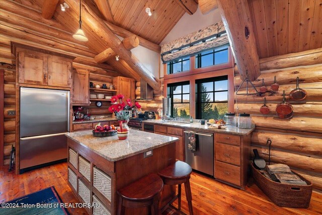 kitchen featuring beam ceiling, brown cabinets, high vaulted ceiling, appliances with stainless steel finishes, and wooden ceiling