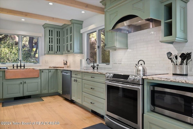 3705 W Mccollister Dr, Teton Village, WY 83025 - kitchen with green cabinetry, a sink, light wood finished floors, premium range hood, and stainless steel appliances