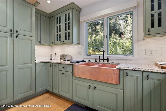 3705 W Mccollister Dr, Teton Village, WY 83025 - kitchen with green cabinetry, a sink, tasteful backsplash, and light wood-type flooring