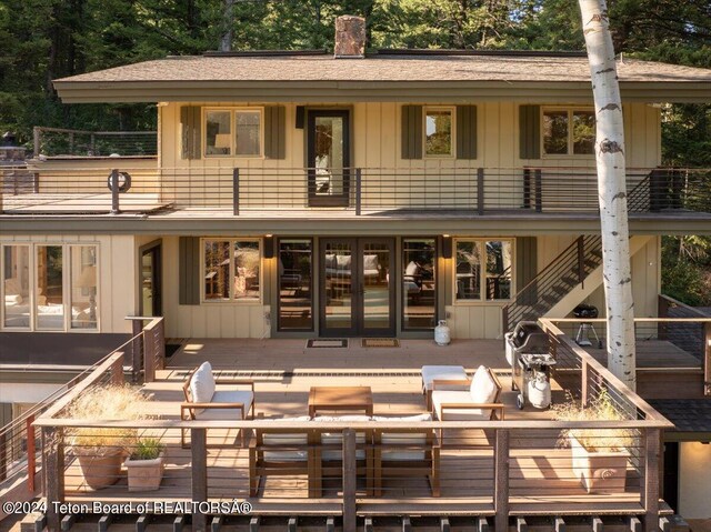 3705 W Mccollister Dr, Teton Village, WY 83025 - rear view of house featuring a balcony, a chimney, a shingled roof, and board and batten siding