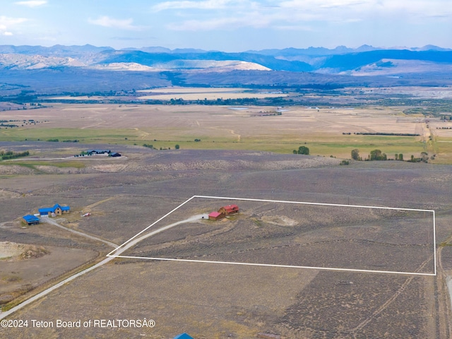 birds eye view of property featuring a water and mountain view and a rural view