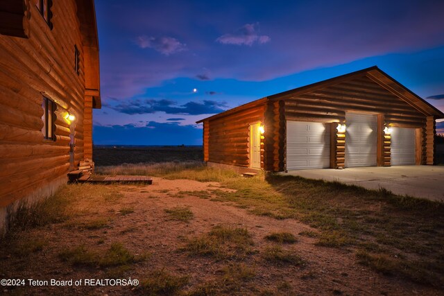 view of garage at dusk